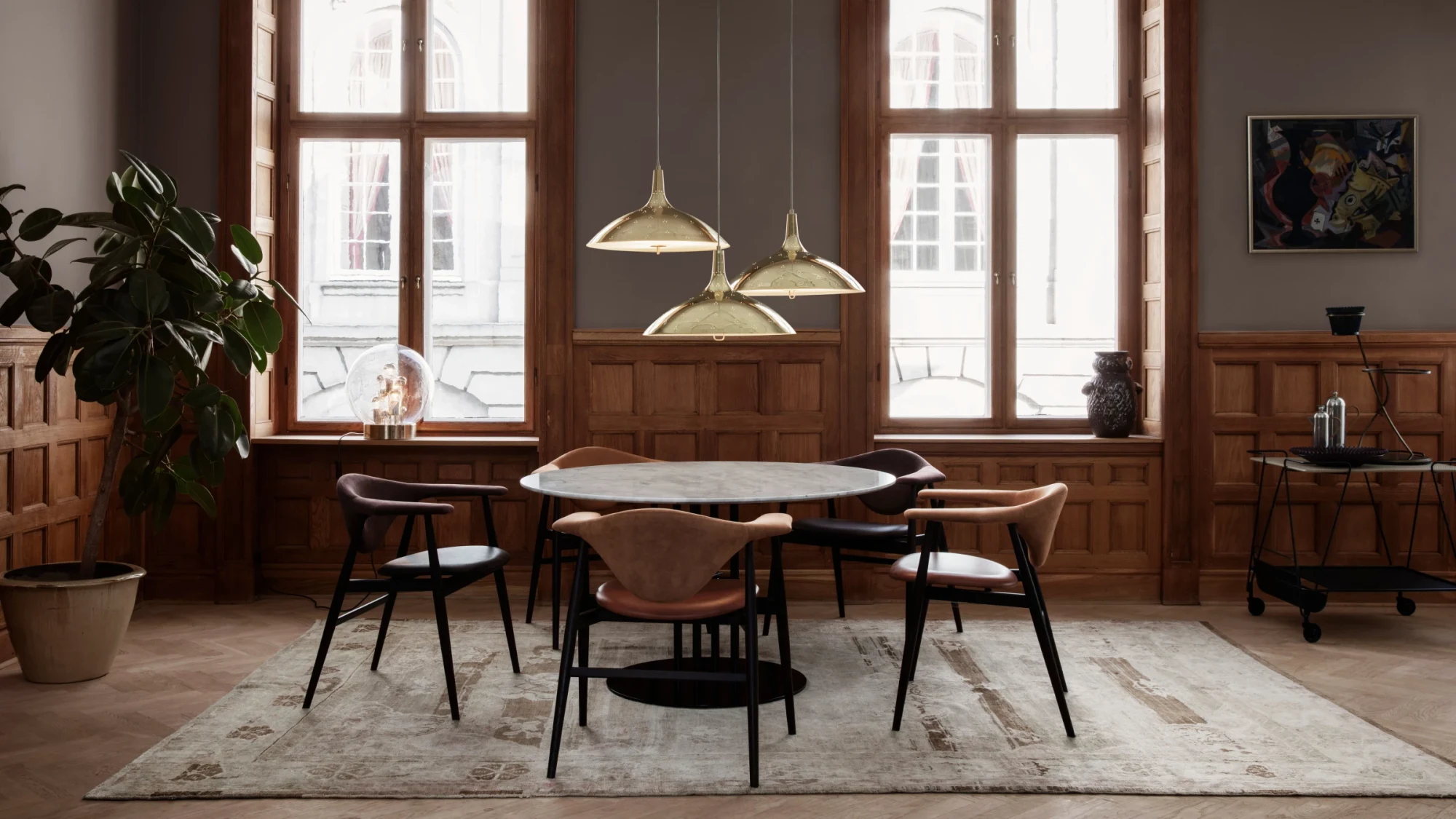 Chaises autour d'une table ronde dans une pièce aux grandes fenêtres