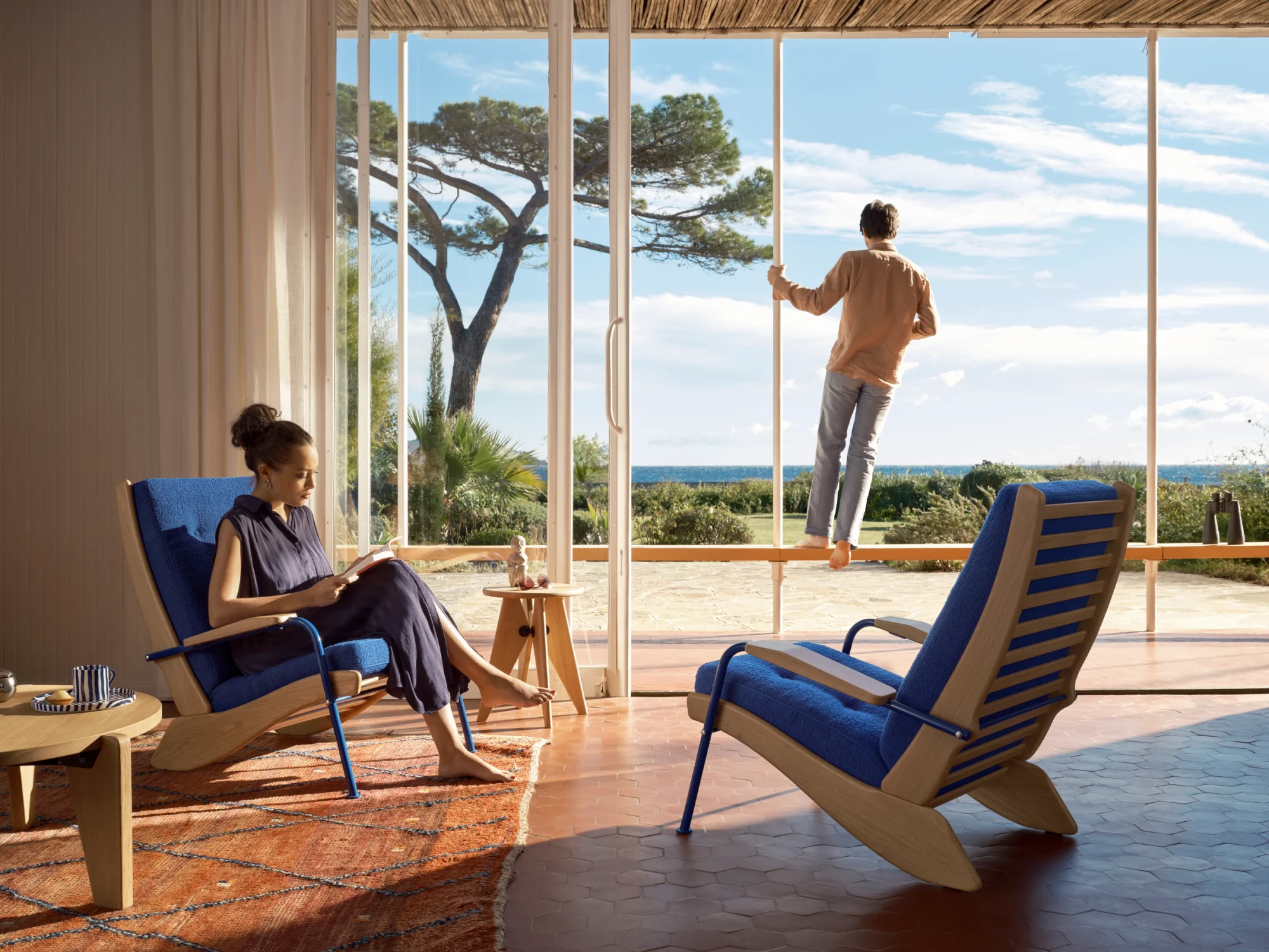 木々と海の眺めが見える部屋に置かれた2脚のFauteuil Kangourou