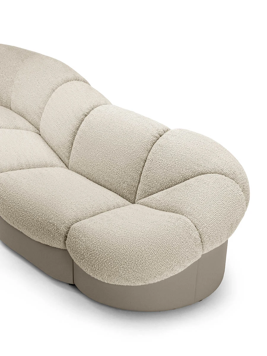 Close view of a sofa end with a rounded, segmented back on a light base