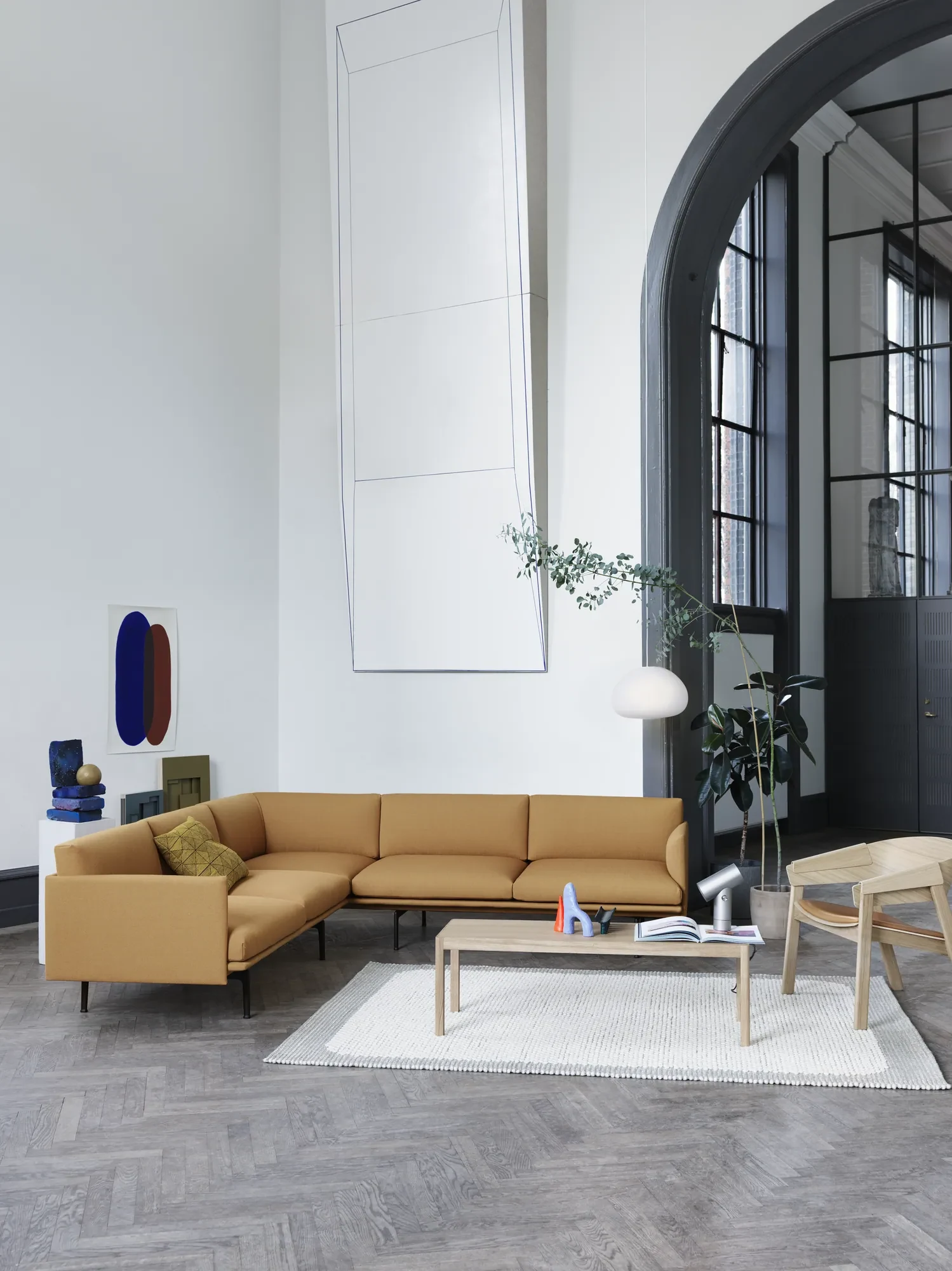 Outline Corner Sofa in a tall hall with a low table and a lounge chair
