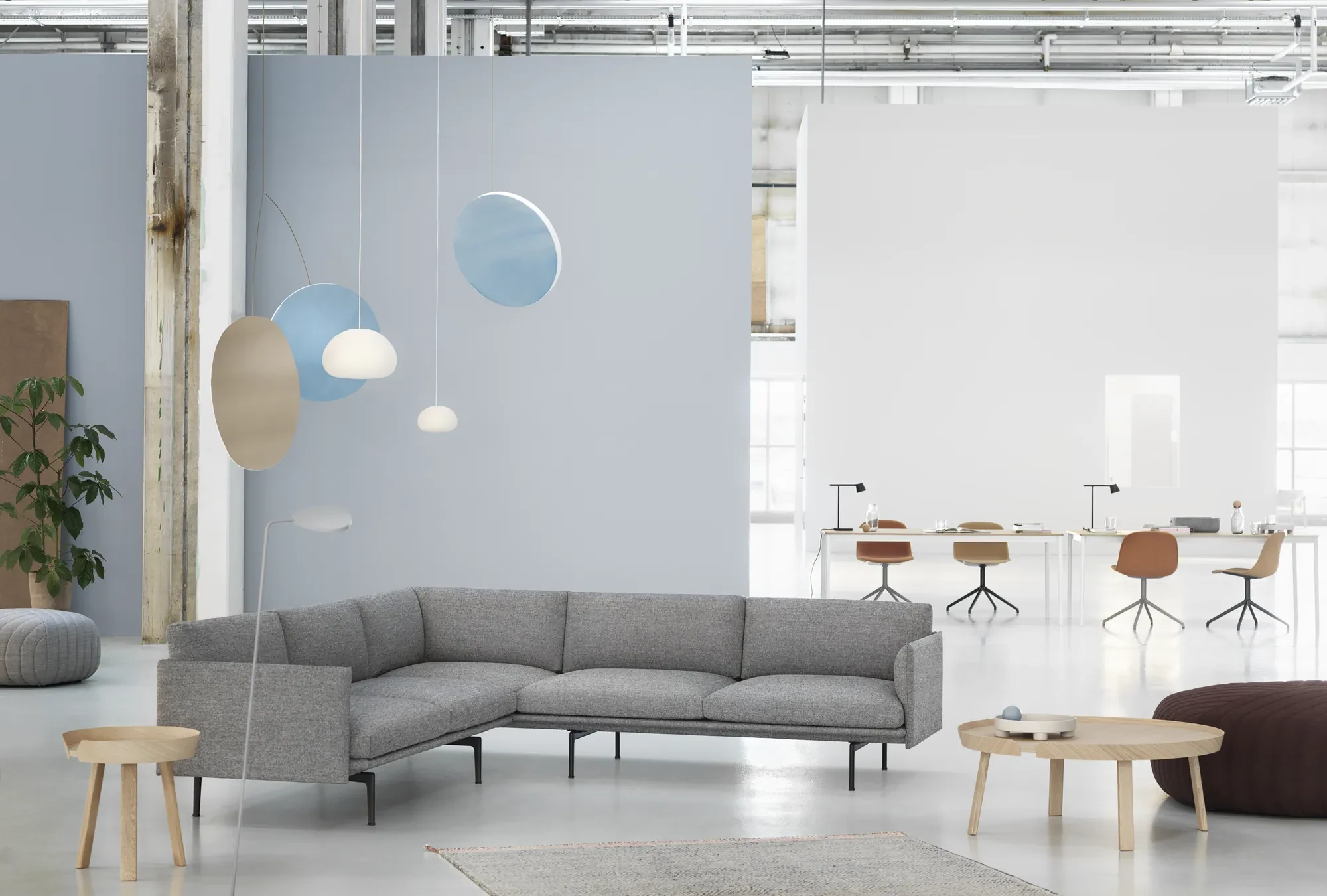 Outline Corner Sofa in an open hall with pendant lamps and low round tables