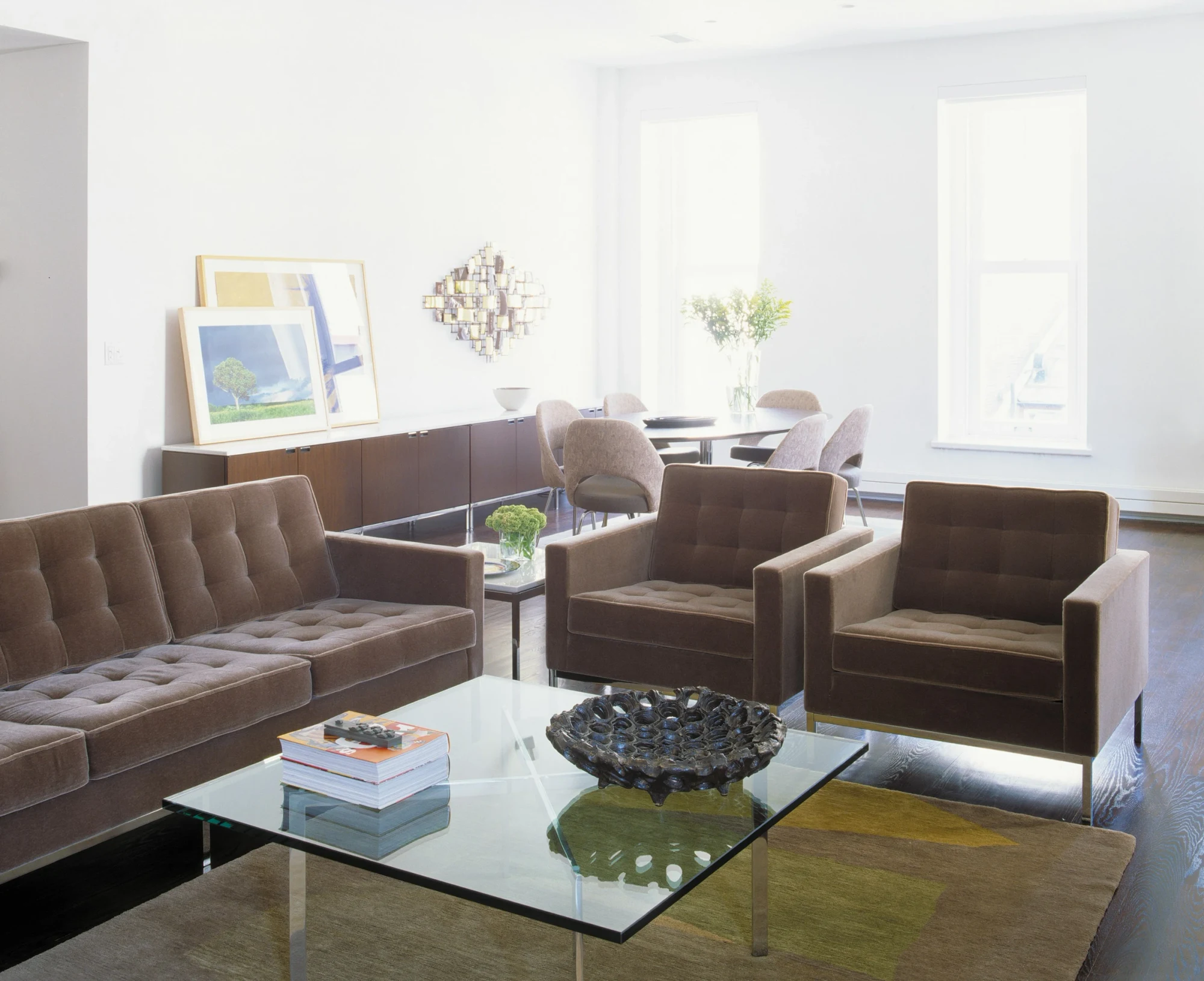 Ein Couchtisch mit Glasplatte, umgeben von Sesseln und Sofas
